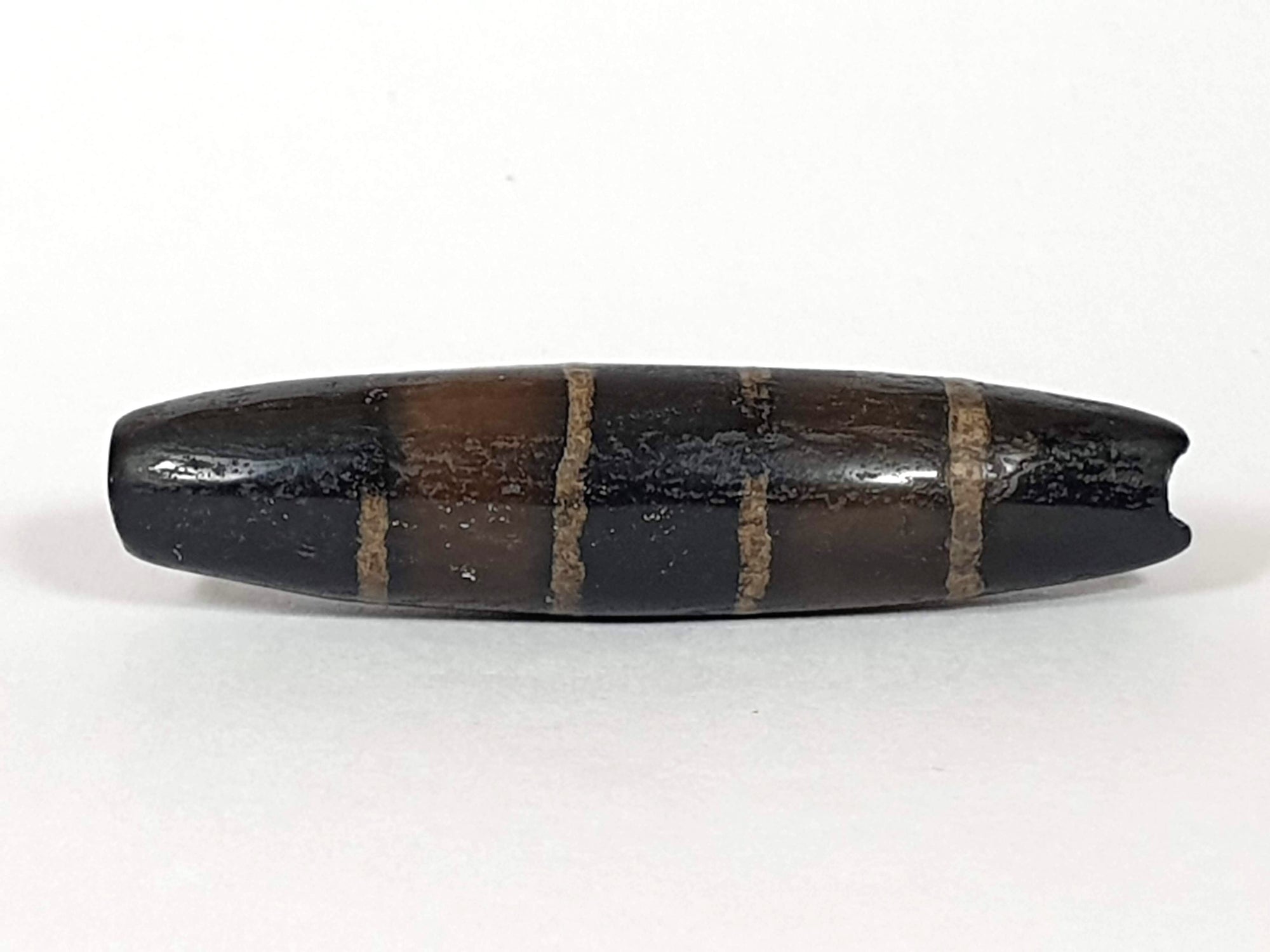 Ancient Seven Stripe Chung Dzi (ACD-SeS-2)- Extremely Old. A rare and extremely old Seven Stripe Chung Dzi bead with profound spiritual significance. This authentic Dzi bead, known for its distinct seven stripe pattern, carries the wisdom and energy of ancient Tibetan culture