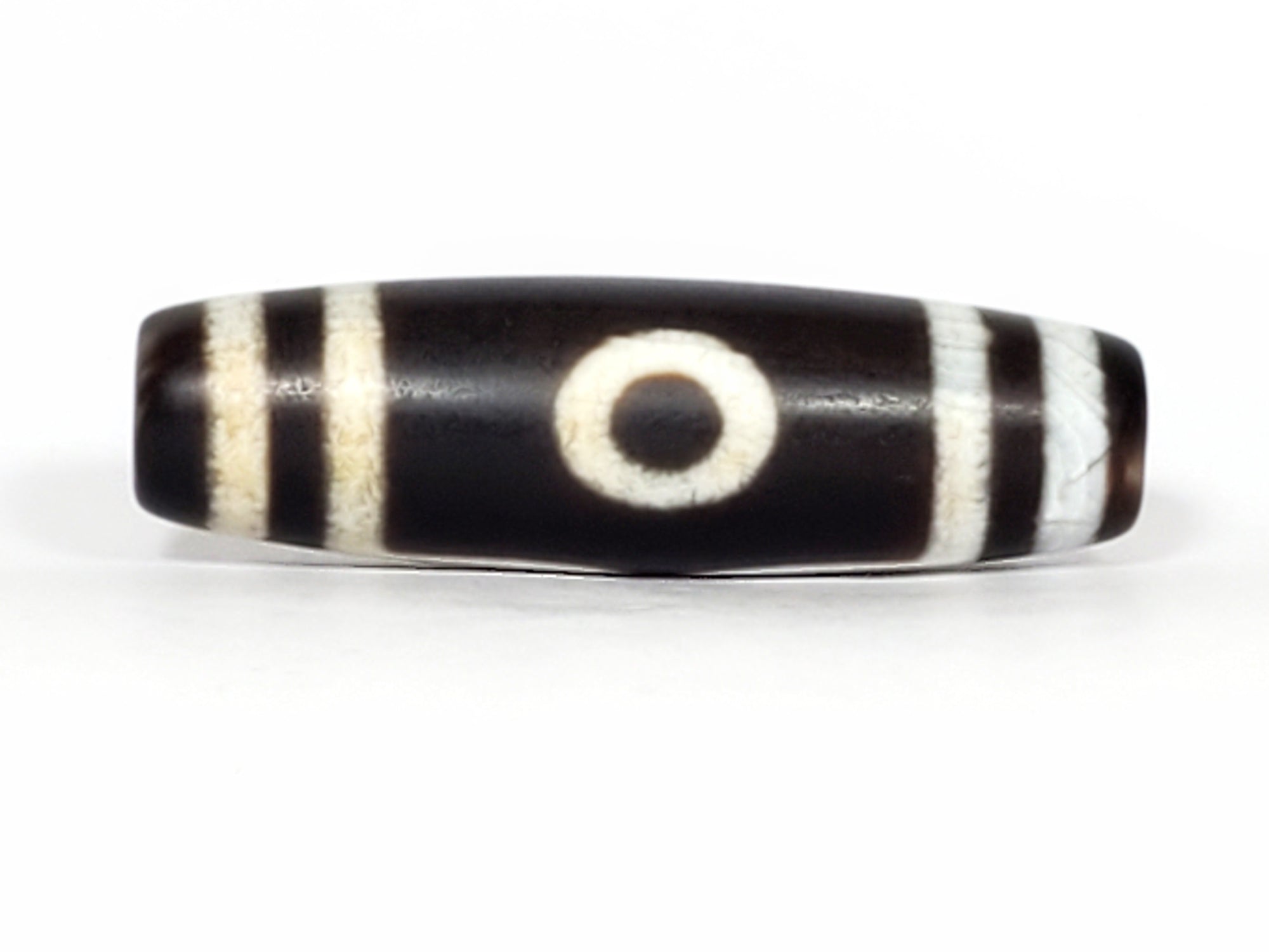 A vintage Dzi bead featuring a captivating Three Eye Motif. This authentic artifact, identified as TaD-ThE-2, showcases the intricate craftsmanship and spiritual symbolism of ancient Dzi bead