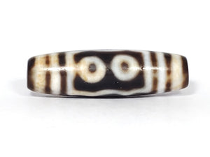 A vintage Dzi bead showcasing a beautiful Five Eye motif. The five intricately carved eyes represent wisdom, clarity, and spiritual insight. This rare and exquisite bead is a treasured piece for collectors and spiritual enthusiasts