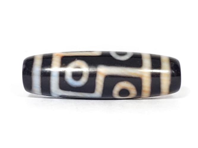 A vintage Dzi bead featuring a captivating Six Eye Motif. This authentic artifact, identified as TaD-V-S-SiE-051423, showcases the intricate patterns and spiritual significance of ancient Dzi beads