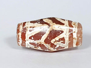  Ancient Lotus & Tiger Tooth Motif Dzi (T1D-LTT-005) - Octagon Shape. An authentic ancient Dzi bead adorned with the enchanting Lotus and Tiger Tooth motif, known for its exceptional condition and rarity. This octagon-shaped bead represents the harmonious blend of grace and strength, symbolizing spiritual purity and protection. With its intricate patterns and weathered appearance, this Dzi bead is a treasured artifact that reflects the rich cultural heritage of Tibetan traditions