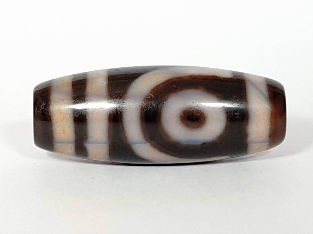 A vintage Dzi bead featuring a captivating Two Eye Motif. This authentic artifact, identified as TD-TwE-1, showcases the intricate craftsmanship and symbolic beauty of ancient Dzi beads.