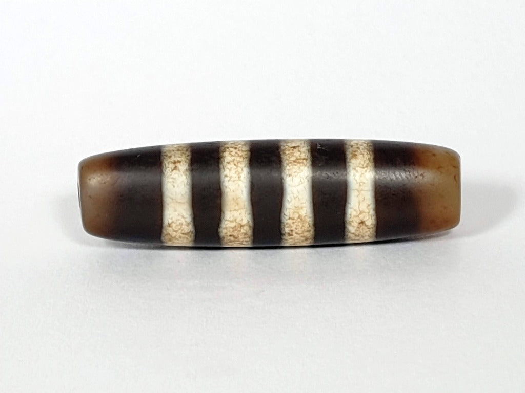 Seven Stripe Chung Dzi" Description: "Authentic Seven Stripe Chung Dzi bead, showcasing its distinctive seven stripe pattern. This ancient artifact carries deep cultural and historical significance