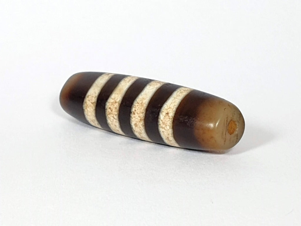 Seven Stripe Chung Dzi" Description: "Authentic Seven Stripe Chung Dzi bead, showcasing its distinctive seven stripe pattern. This ancient artifact carries deep cultural and historical significance