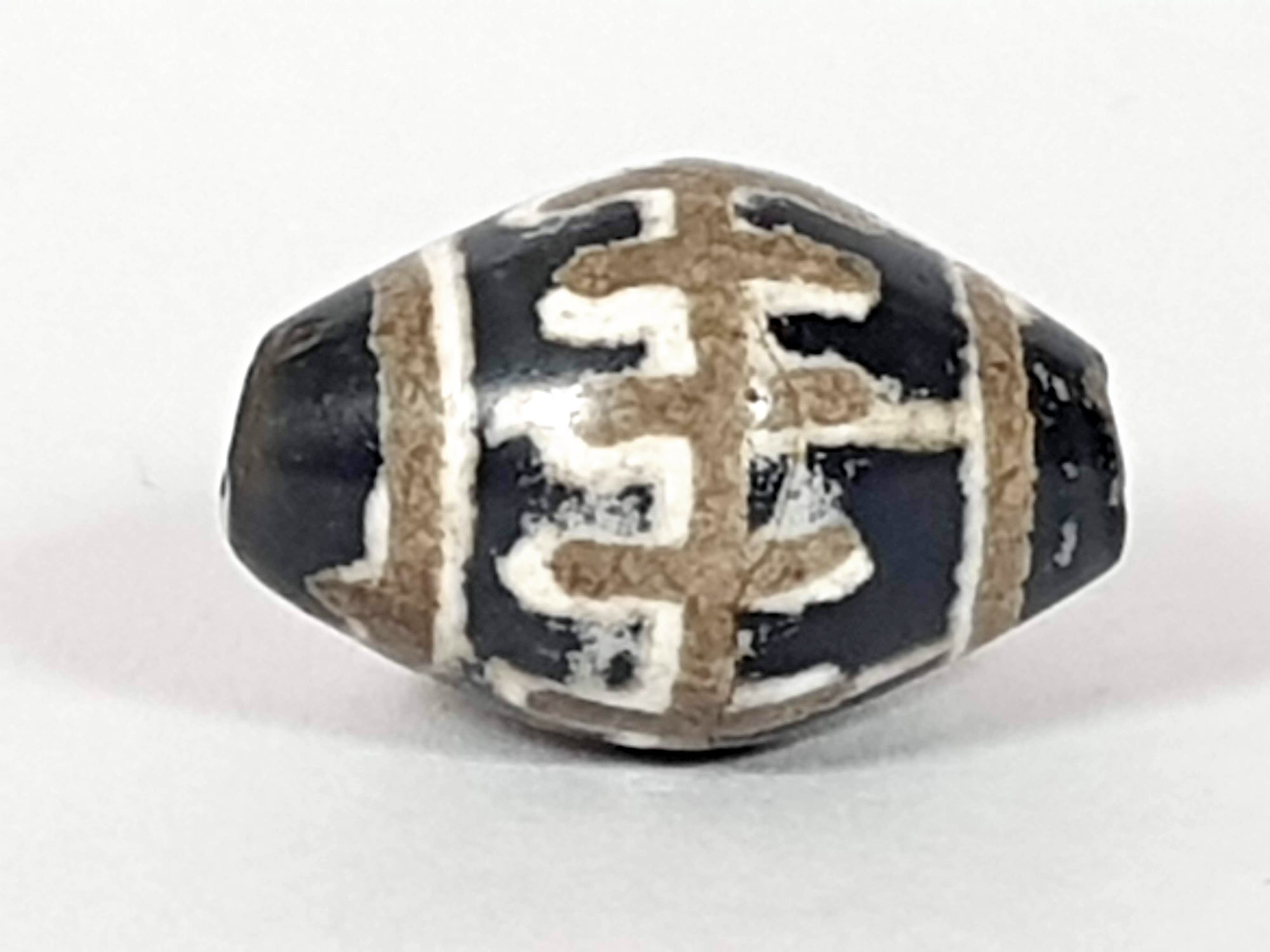 ancient Indus Valley dzi bead adorned with sun rays with calcification