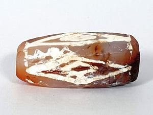  ancient Dzi bead made from Carnelian, showcasing a unique and highly sought-after Four Diamond Eye-In-Eye & Wave motif. This bead is exceptionally rare, adding to its collectability and value. The intricate design combines protective symbolism with the fluidity and power of waves, making it a remarkable piece of ancient craftsmanship and spiritual significance."