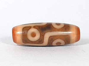 rare orangish pink dzi bead from Tibet featuring six eye motif