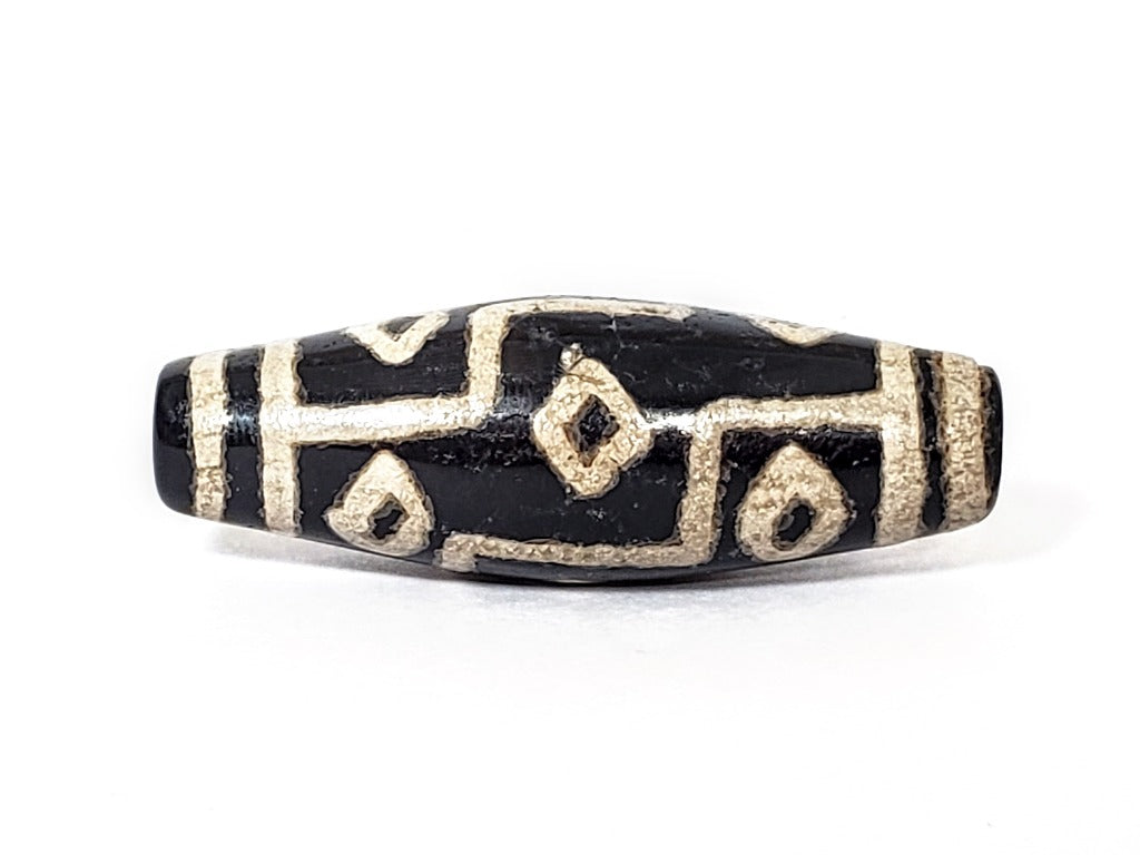 A vintage Dzi bead with a faux antique appearance featuring a captivating nine-eye motif. The intricate patterns and aged texture give it a sense of ancient mystique and cultural significance. The nine eyes symbolize protection, wisdom, and spiritual enlightenment