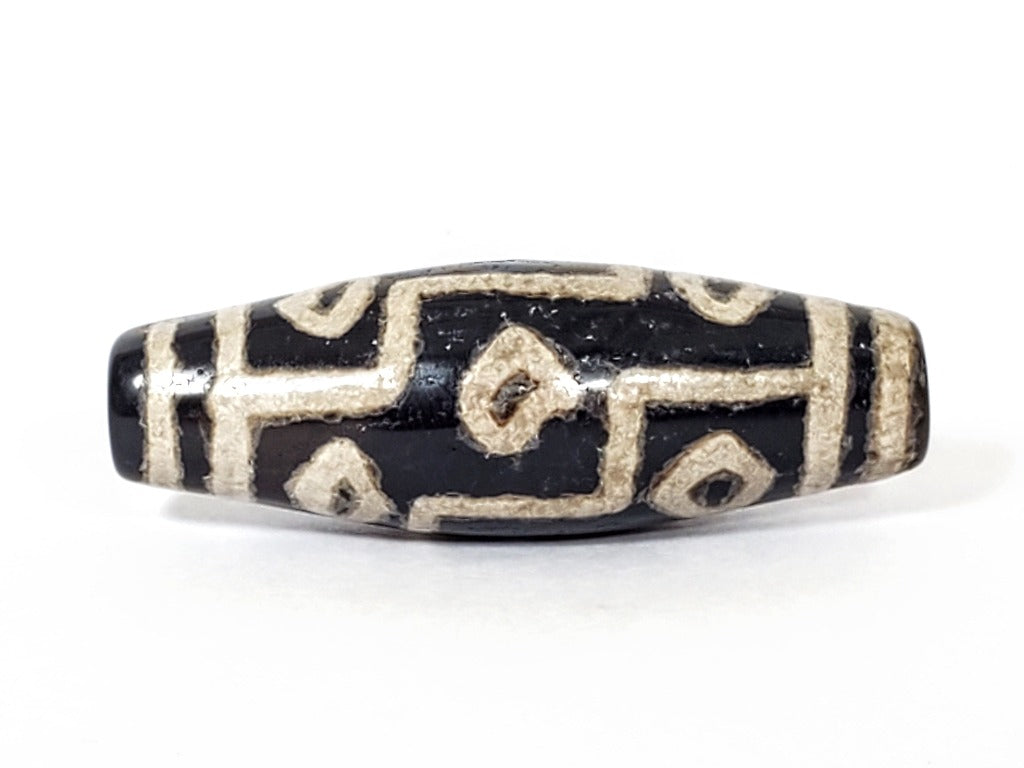 A vintage Dzi bead with a faux antique appearance featuring a captivating nine-eye motif. The intricate patterns and aged texture give it a sense of ancient mystique and cultural significance. The nine eyes symbolize protection, wisdom, and spiritual enlightenment