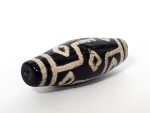 A vintage Dzi bead with a faux antique appearance featuring a captivating nine-eye motif. The intricate patterns and aged texture give it a sense of ancient mystique and cultural significance. The nine eyes symbolize protection, wisdom, and spiritual enlightenment