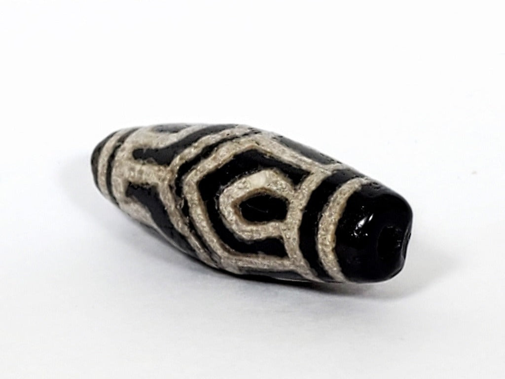 A vintage Dzi bead with a faux antique appearance featuring a beautiful six-eye lotus motif. The bead showcases intricate carvings resembling the delicate petals of a lotus flower, with six eyes symbolizing wisdom and insight. This unique bead exudes a sense of elegance and spirituality, making it a captivating addition to any jewelry collection