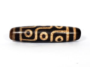 A vintage Dzi bead with a faux antique appearance featuring a mesmerizing nine-eye motif. The intricate details and weathered texture give it an aura of ancient wisdom and spirituality. 