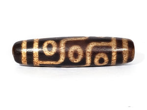 A vintage Dzi bead with a faux antique appearance featuring a mesmerizing nine-eye motif. The intricate carvings and weathered texture give it an ancient look, evoking a sense of spiritual power and wisdom. The nine eyes symbolize protection, insight, and spiritual enlightenment. 