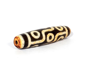 A vintage Dzi bead with a faux antique appearance featuring a captivating nine-eye motif. The bead showcases intricate carvings and a weathered texture, evoking a sense of ancient mystique and spiritual significance