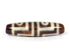 A vintage Dzi bead featuring a stunning Four Eye motif. The intricately carved eyes symbolize protection and spiritual insight. This exquisite bead is a prized collectible for Dzi bead enthusiasts.