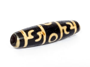 A vintage Dzi bead featuring the intricate Guru Rinpoche's Ritual Paraphernalia motif with a large keyhole drilling. This unique and rare artifact embodies the spiritual significance and artistic craftsmanship of Dzi beads