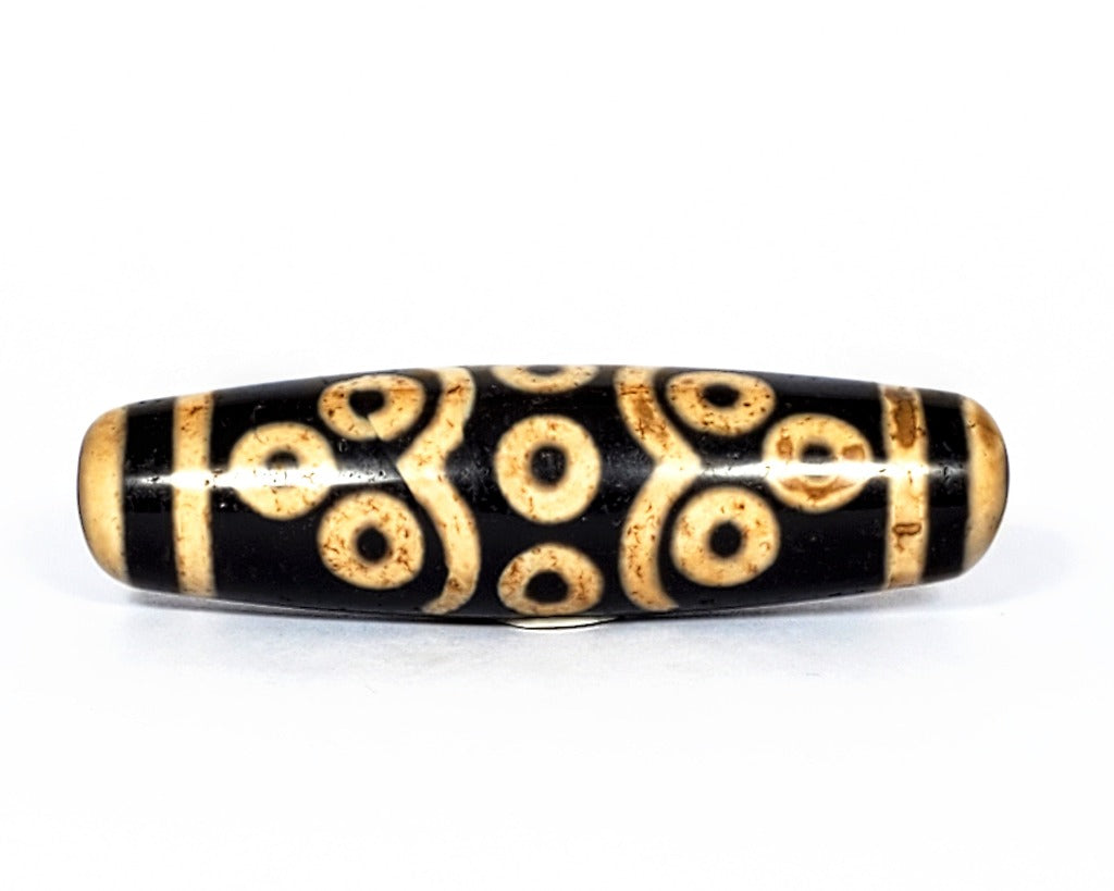 A vintage Dzi bead featuring a stunning Fourteen Eye motif with a large keyhole drilling. This rare and intricate artifact carries deep spiritual symbolism and represents auspiciousness and protection