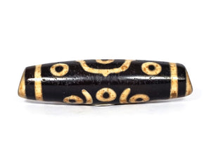 A vintage Dzi bead featuring a stunning Fourteen Eye motif with a large keyhole drilling. This rare and intricate artifact carries deep spiritual symbolism and represents auspiciousness and protection