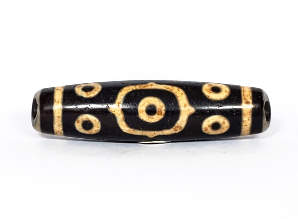 A vintage Dzi bead featuring a stunning Fourteen Eye motif with a large keyhole drilling. This rare and intricate artifact carries deep spiritual symbolism and represents auspiciousness and protection