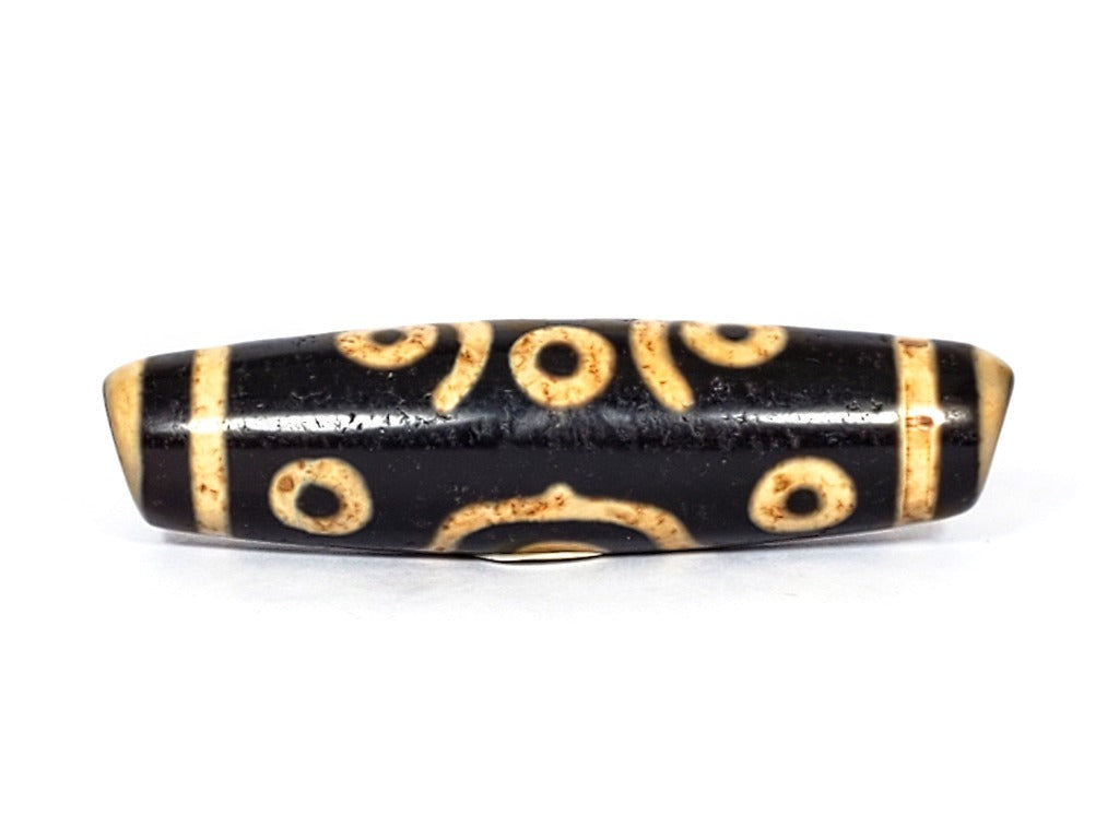 A vintage Dzi bead featuring a stunning Fourteen Eye motif with a large keyhole drilling. This rare and intricate artifact carries deep spiritual symbolism and represents auspiciousness and protection