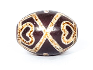 A vintage Dzi bead featuring a round shape adorned with a captivating Four Eye Lotus & Cross motif. This authentic artifact, identified as R-FoELC, showcases the intricate patterns and spiritual symbolism of ancient Dzi beads