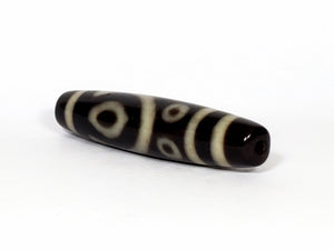 A vintage Dzi bead featuring a unique and rare variant of the Four Eye motif. This intricately carved bead showcases four eyes and carries deep spiritual significance. A collector's item with distinctive beauty