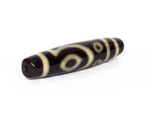 A vintage Dzi bead featuring a unique and rare variant of the Four Eye motif. This intricately carved bead showcases four eyes and carries deep spiritual significance. A collector's item with distinctive beauty