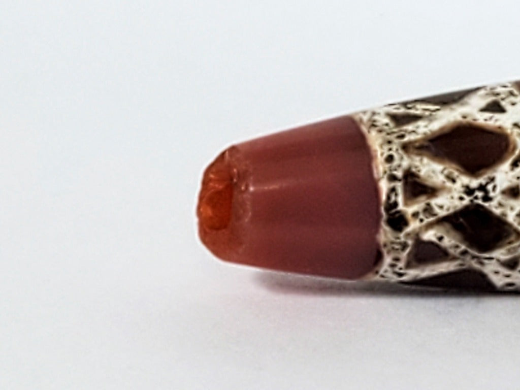 Genuine ancient Dzi bead featuring an intricate criss cross motif in captivating carnelian. Its unique hexagon shape adds to its historical charm.