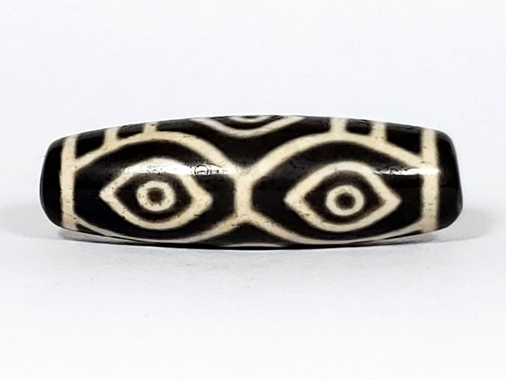 Vintage Dragon Eye Dzi Bead" Description: "A mesmerizing vintage Dzi bead featuring a captivating dragon eye motif. The intricate details and vibrant colors of the bead create an aura of mystique and power