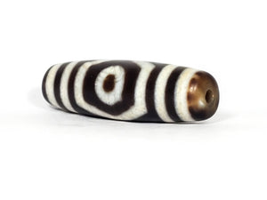 A vintage Dzi bead featuring a mesmerizing Three Eye Motif. This authentic artifact, identified as TaD-ThE-1, showcases the intricate craftsmanship and spiritual significance of ancient Dzi beads