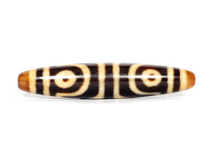 ancient Dzi bead adorned with a powerful Four Eye & Tiger Tooth motif. This bead carries deep spiritual symbolism, representing enhanced perception, inner strength, and protection. The Four Eye motif symbolizes heightened spiritual vision, while the Tiger Tooth motif embodies courage and warding off negative energies