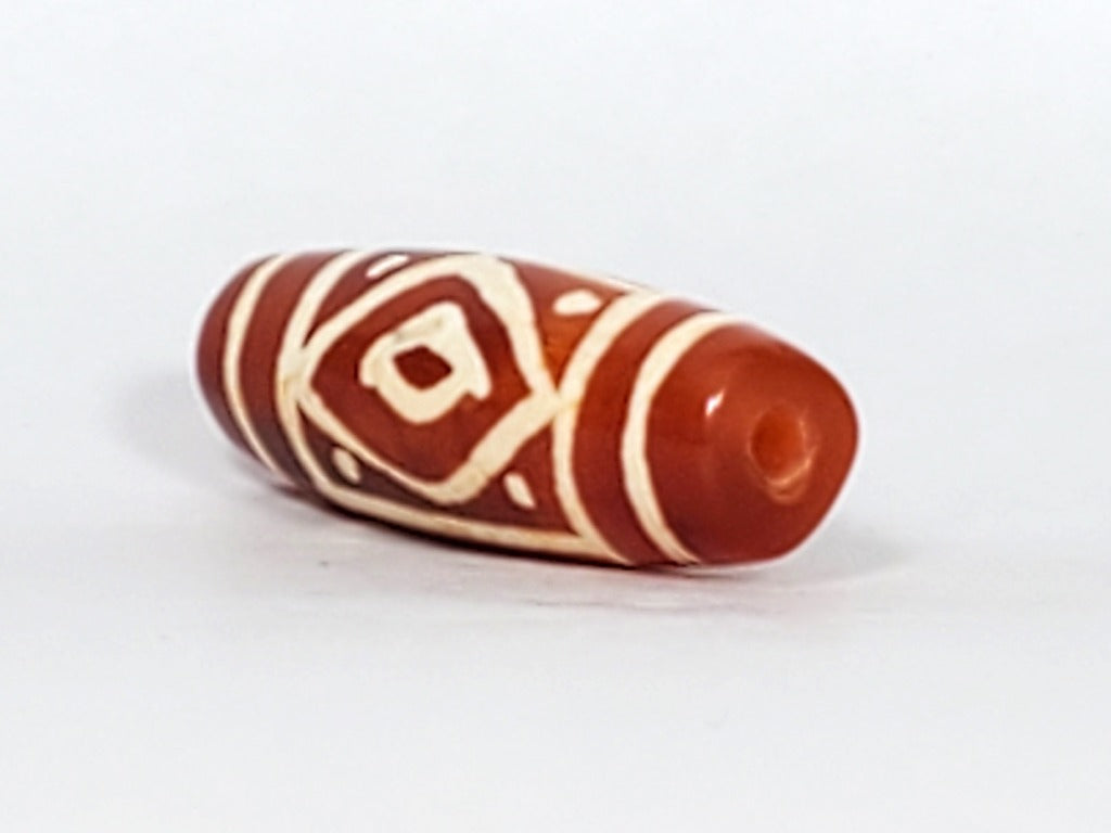 Collectible Diamond Eye-In-Eye & Star Motif Carnelian Dzi Bead" Description: "Collectible Dzi bead carved from carnelian, adorned with an enchanting Diamond Eye-In-Eye & Star motif. This bead holds immense collectible value and artistic charm."