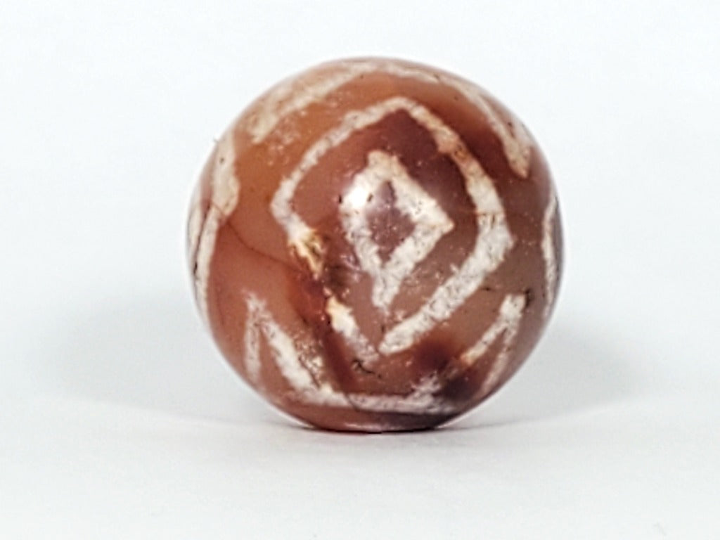 Authentic Ancient Round Diamond Eye-In-Eye & Tiger Tooth Motif Carnelian Dzi Bead (CD-DEIETT-R1). An authentic and ancient round Dzi bead adorned with the captivating Diamond Eye-In-Eye and Tiger Tooth motifs.