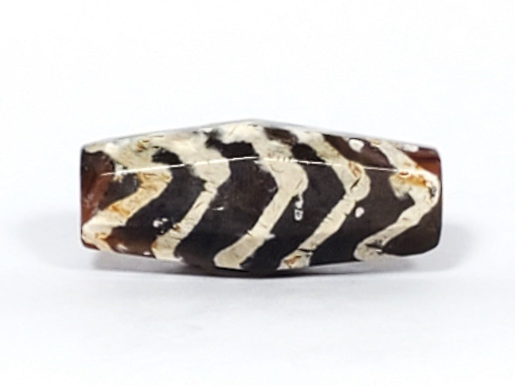  Ancient Dzi Bead - Five Tiger Stripe Motif Carnelian with Calcification. A highly collectible ancient Dzi bead carved from Carnelian, showcasing an intricate Five Tiger Stripe motif. The bead presents intriguing calcification patterns, making it a unique and sought-after piece among collectors. The Five Tiger Stripe motif carries ancient symbolism associated with strength, bravery, and protection