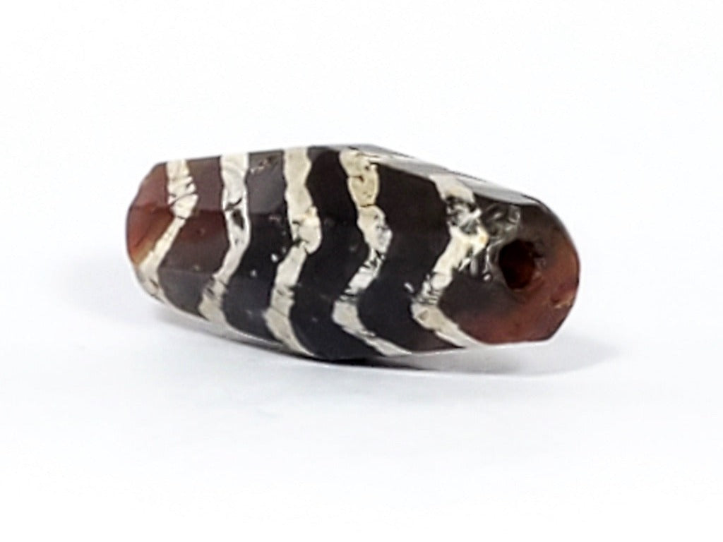  Ancient Dzi Bead - Five Tiger Stripe Motif Carnelian with Calcification. A highly collectible ancient Dzi bead carved from Carnelian, showcasing an intricate Five Tiger Stripe motif. The bead presents intriguing calcification patterns, making it a unique and sought-after piece among collectors. The Five Tiger Stripe motif carries ancient symbolism associated with strength, bravery, and protection