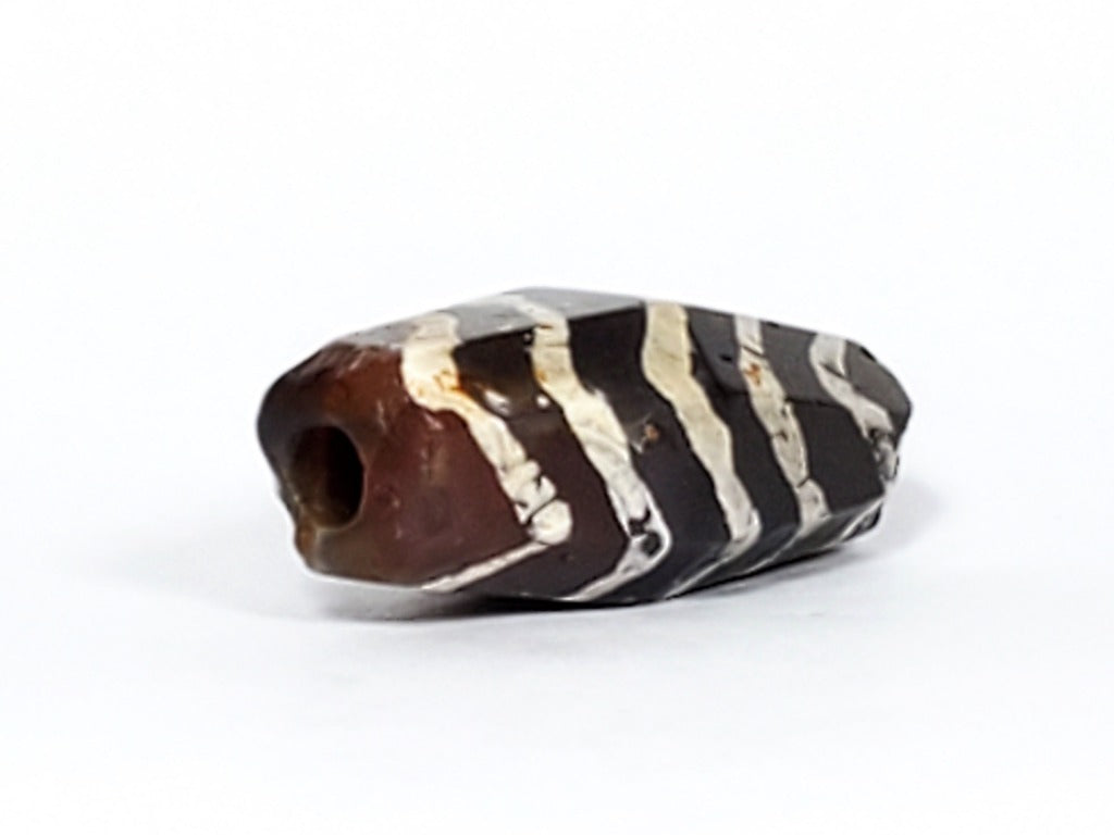  Ancient Dzi Bead - Five Tiger Stripe Motif Carnelian with Calcification. A highly collectible ancient Dzi bead carved from Carnelian, showcasing an intricate Five Tiger Stripe motif. The bead presents intriguing calcification patterns, making it a unique and sought-after piece among collectors. The Five Tiger Stripe motif carries ancient symbolism associated with strength, bravery, and protection