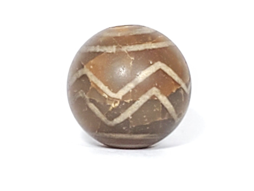 Ancient Round Double Wave Motif Dzi Bead. An authentic ancient round Dzi bead featuring a stunning Double Wave motif. This Dzi bead is a true reflection of the skilled craftsmanship and artistic expression of Tibetan artisans