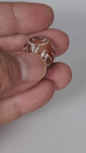 Authentic Ancient Round Diamond Eye-In-Eye & Tiger Tooth Motif Carnelian Dzi Bead (CD-DEIETT-R1). An authentic and ancient round Dzi bead adorned with the captivating Diamond Eye-In-Eye and Tiger Tooth motifs.