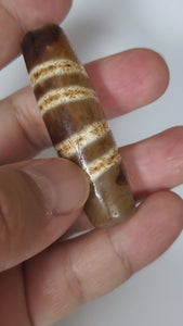  "Authentic and rare old Tibetan Seven Stripe Motif Dzi Bead, showcasing its unique design and cultural significance."